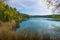 Beautiful lake of extraordinary color hidden in the forest. Water illuminated by the sun on a cheerful spring or summer day. Lake