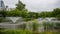 Beautiful lake with fountains, green grass and trees in the nature park in Suel