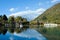 The beautiful lake in the sunny day with little cloudy reflection on water surface background by the mountain cover by snow using