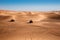 Beautiful landscape of arabic desert sand dunes with two riding quad buggy bikes