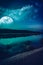 Beautiful landscape of blue sky with cloud and super moon above silhouettes of trees at riverside. Serenity nature background,