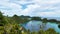 Beautiful landscape of bunch of hills surrounded clear tosca water and bright blue sky and white clouds, Raja Ampat