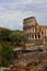 Beautiful landscape of Coliseum near the green trees under the b