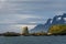 Beautiful landscape of Coopers Bay from the water, rocky spit lit by sunbeam against a moody sky, South Georgia, southern Atlantic