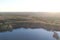 Beautiful landscape with forest and pond at sunset. Flying photo in rural areas.