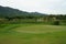 Beautiful landscape of a golf court with green grass and mountain background