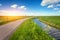 Beautiful landscape with green grass field, road, lighthouse