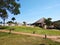 A beautiful landscape with a house of thatch, shrub and lawn