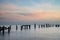 Beautiful landscape image of colorful sunrise over ocean and derelict pier in distance