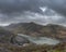 Beautiful landscape image of Dinorwig Slate Mine and snowcapped Snowdon mountain in background during Winter in Snowdonia with