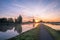 Beautiful landscape image with traditional dutch windmill and low fog at sunrise