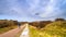 Beautiful landscape - lonely cyclist who rides the bike path among the dunes