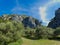 Beautiful landscape in the Luberon in Provence with a field of olive trees, rocky hills and a white cloud all in length that