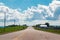 Beautiful landscape midday view of Canadian Ontario empty countryside road during sunny day with white clouds in blue sky.