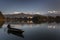 Beautiful landscape with Phewa Lake and boat on lake, mountains in background also as reflectaion on lake.  Machapuchare-FIshtail