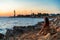 Beautiful landscape picture of a lighthouse and a woman looking the sunset