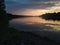 Beautiful landscape with river, forested riparian zone and hazy mountains in distance during cloudy evening