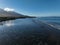 Beautiful landscape of a sea with foamy waters and corals with a mountain in the background