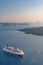 Beautiful landscape with sea view on the Sunset. Cruise liner in the Aegean Sea, Thira, Santorini island, Greece. Summer seascape