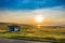 Beautiful landscape with a small house on the hills in the sunset