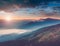 Beautiful landscape of summer mountains at sunrise. Misty slopes of the mountains in the distance.