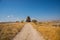 Beautiful landscape in Sunny weather. The road in the field, in the distance an unusual rock. Cappadocia, Turkey