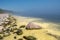 Beautiful landscape at sunrise. Clean, calm sea in the mist and rocky shore in summer morning.