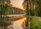 Beautiful landscape of sunset, forest edge and water body.