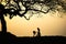 Beautiful landscape with trees silhouette at sunset with Vietnamese woman wearing traditional dress Ao Dai standing under the tree