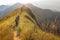 Beautiful landscape with trekkers walking on mountain ridge in sunset at Khao Chang Phuak, Thong Pha Phum National Park,