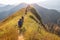 Beautiful landscape with trekkers walking on mountain ridge in sunset at Khao Chang Phuak, Thong Pha Phum National Park,