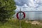 Beautiful landscape view of Baltic sea  coast. Lifebuoy on water surface and cloudy sky background. Sweden.