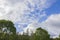 Beautiful landscape view of blue sky with white clouds over tops of forest trees.