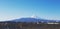 Beautiful landscape view of Fuji mountain and clear blue sky with many roof home and grass field for foreground.