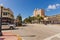 Beautiful landscape view of street of Miami Beach. White buildings and palm trees on both sides of asphalt road.