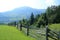 Beautiful landscape with view to wooden fence, pasture, forest a