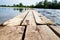 Beautiful landscape with water of calm lake and wooden walkway in a summer day. Concept of a walk, rest and travel on nature or in