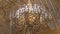 Beautiful large crystal chandelier in a royal environment. Interior elements - decorated ornate ceiling large luxury