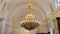 Beautiful large crystal chandelier in a royal environment. Interior elements - decorated ornate ceiling large luxury