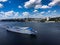 A beautiful large four-deck tourist ship of white and blue color floats on the river