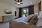 Beautiful large luxury new bedroom with great design, beige, grey and white tones, TV bove dresser, rich wooden doors, window
