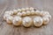 Beautiful large necklace on a wooden background. Close-up. Big pearls.