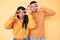 Beautiful latin young couple wearing casual clothes together trying to open eyes with fingers, sleepy and tired for morning