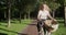 Beautiful laughing happy girl teenager rides bicycle in park, girl rides on camera