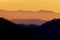 Beautiful layers of hills with bright orange sky in background