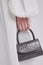 Beautiful leather grey handbag in girl`s hand.