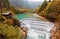 Beautiful Lech Waterfall cascading down from an emerald lake surrounded by autumn colors of lakeside forests in Fussen, Bavaria