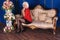 Beautiful legged blonde model in black miniskirt and black stockings posing on sofa