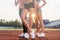 Beautiful legs of three athlete fit women at stadium.