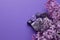 Beautiful lilac flowers and semi-precious amethyst druze lie on a purple background. Copy space